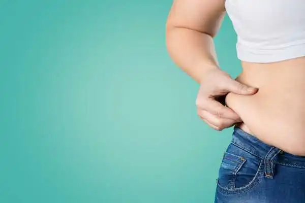 Image of woman pinching her love handles to show weight gain Northolt